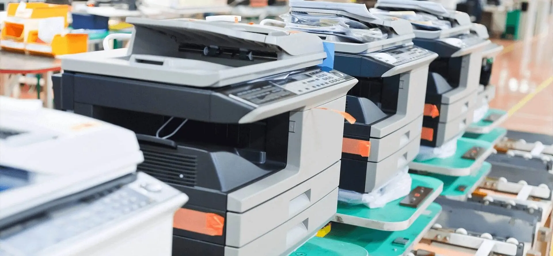 A row of copiers are lined up on the floor.